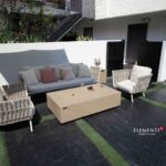 a patio with a couch and chairs and firepit table