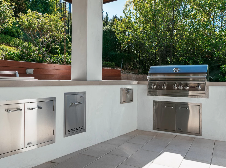 Lion Premium Grill and stainless steel storage components built into a custom stucco outdoor kitchen island