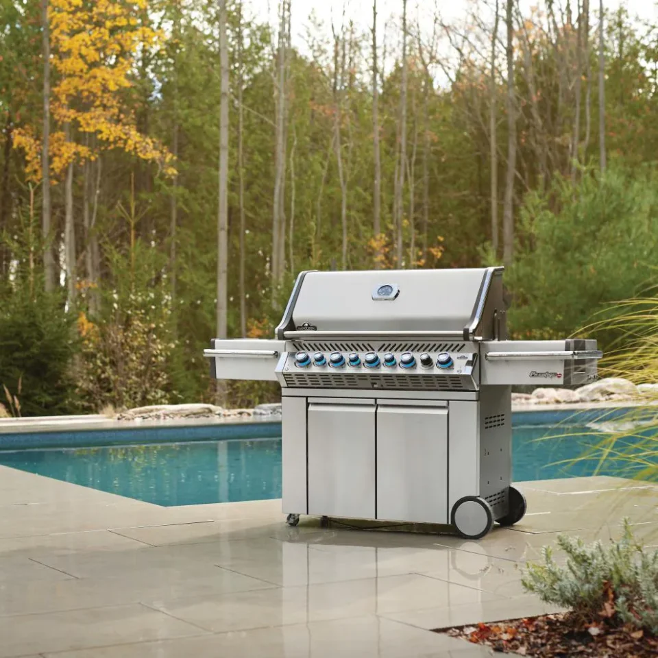 High end BBQ grills like the Napoleon Prestige PRO freestanding gas grill with blue LED knobs, shown beside a backyard pool