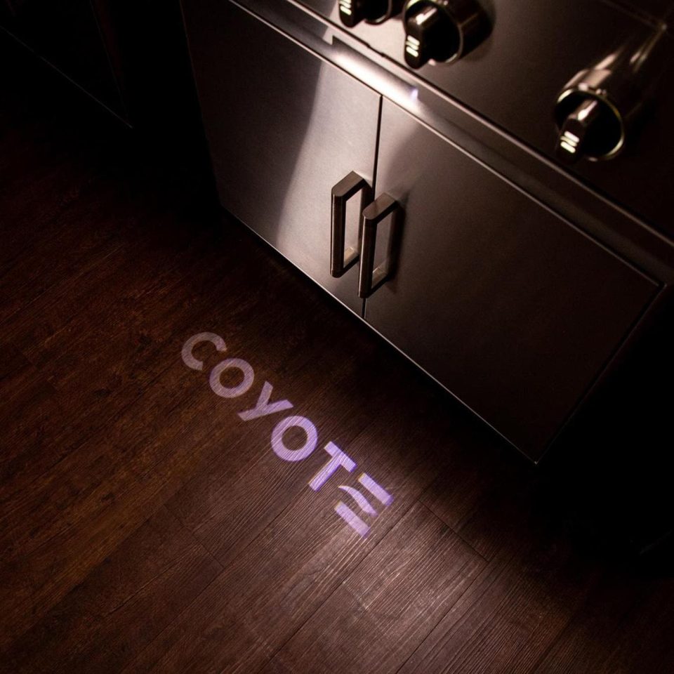 SL Series Coyote grill projecting the Coyote logo onto the ground using throw light feature