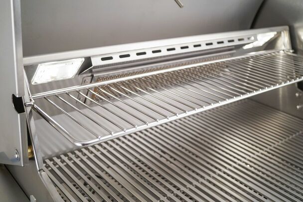 Interior of AOG L-Series grill with halogen lights and stainless steel grates.