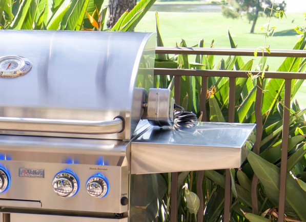 AOG built in barbecue grill installed in a tropical outdoor kitchen, showcasing durable stainless steel construction and backlit control knobs