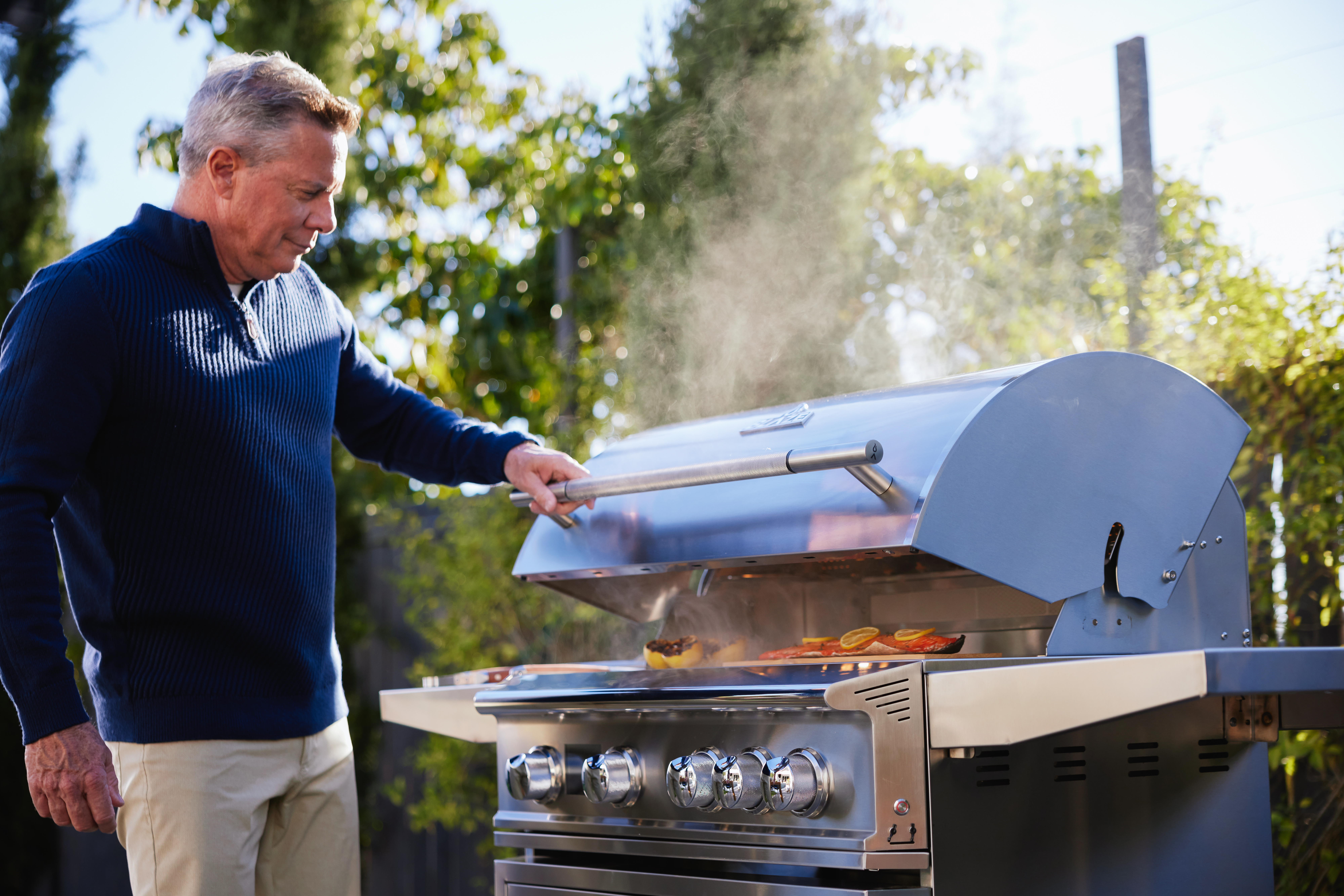 Man grilling outdoors using Blaze Outdoor Products freestanding LTE PRO gas grill in a backyard setting