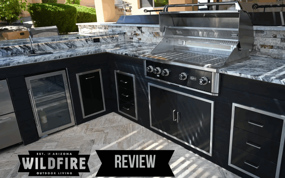 Wildfire Outdoor Living outdoor kitchen setup with stainless steel grill, storage drawers, and built-in refrigerator in luxury backyard
