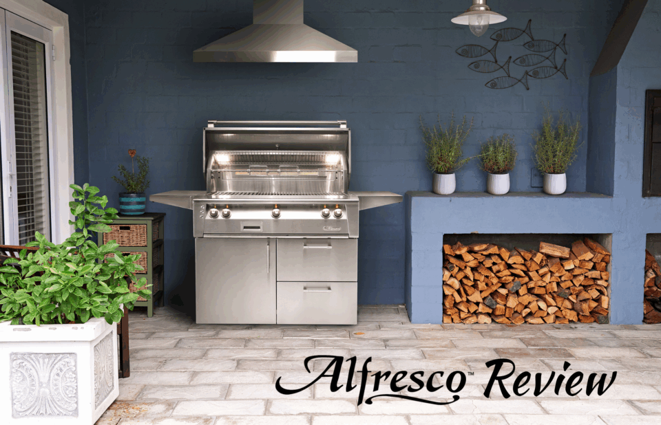 Alfresco Grills Review featuring a luxury stainless steel built-in grill setup with outdoor kitchen island, wood storage, and modern backyard design