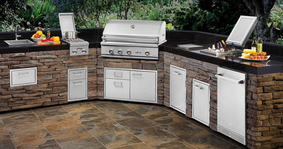 Delta Heat outdoor kitchen island featuring built in grill, side burner, sink, and stainless steel storage components